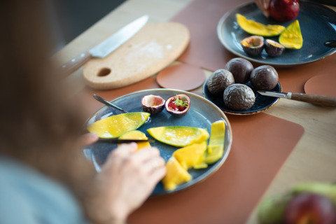 Verse mango en passievrucht op bordjes in het strandhuis Sea Lodges Zandvoort 6 in Nederland.