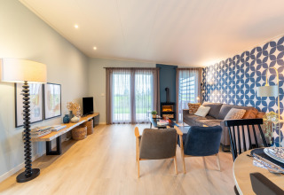 Bright, modern living room at 'By the Baker' lodge in the Netherlands with large windows and chic decor.