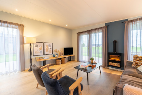 Wohnzimmer in der Lodge «By the Baker» in den Niederlanden mit modernen Möbeln und großen Fenstern.