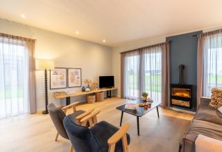 Wohnzimmer in der Lodge «By the Baker» in den Niederlanden mit modernen Möbeln und großen Fenstern.