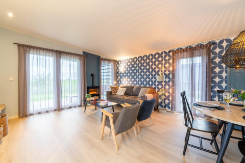 Helles, modernes Wohnzimmer in der Lodge 'By the Baker' in den Niederlanden mit stilvollem Interieur und Mustertapete.