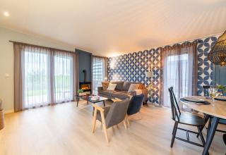 Bright, modern living space in 'By the Baker' lodge in the Netherlands with geometric wall and Scandinavian decor.
