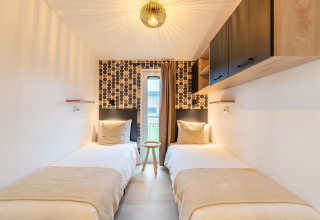 Modernes Zimmer im Lodge 'By the Baker' in den Niederlanden mit zwei Einzelbetten und stilvollem Design.