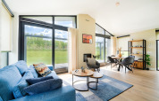 Heldere, moderne woonkamer met grote ramen en uitzicht op groen, vlakbij Kaag Lakes en Leiden Canals in Nederland.