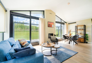 Salon lumineux et moderne avec baies vitrées, vue sur la verdure près des Kaag Lakes et des canaux de Leiden aux Pays-Bas.
