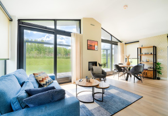 Salon lumineux et moderne avec baies vitrées, vue sur la verdure près des Kaag Lakes et des canaux de Leiden aux Pays-Bas.