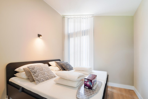 Chambre lumineuse et moderne avec lit double, oreillers et linge à Holiday home près des Kaag Lakes, Pays-Bas.
