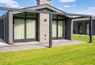 Vue extérieure d’une maison de vacances moderne avec grandes fenêtres et terrasse près des lacs Kaag, Pays-Bas.