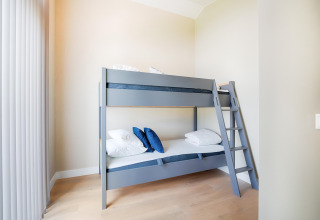 Chambre lumineuse avec un lit superposé gris à Holiday home près des lacs Kaag et des canaux de Leiden, Pays-Bas.