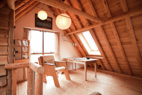 Knusse houten zolderkamer met bureau in de cabine De Schone Leij, Nederland, vol daglicht.