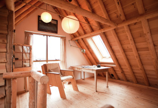 Knusse houten zolderkamer met bureau in de cabine De Schone Leij, Nederland, vol daglicht.