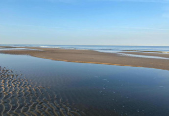 Photo of a tranquil beach with sandbanks and shallow water, taken at cabin 'De Schone Leij' in the Netherlands.
