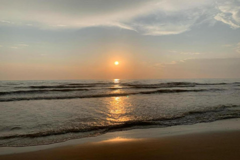 Zonsondergang boven de zee met zachte golven, gezien vanaf het strand bij 'De Schone Leij' in Nederland.