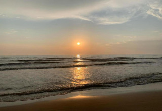 Zonsondergang boven de zee met zachte golven, gezien vanaf het strand bij 'De Schone Leij' in Nederland.