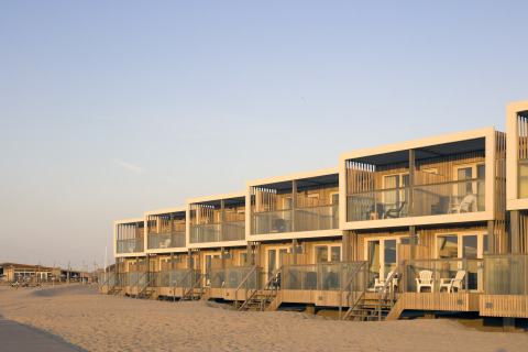 Moderne Strandhäuser im Resort Hoek van Holland, Niederlande, mit Terrassen am Sandstrand bei Sonnenuntergang.