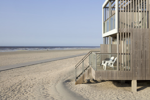 Modernes Strandhaus mit Holzfassade und Balkon am Sandstrand im Resort Hoek van Holland, Niederlande.