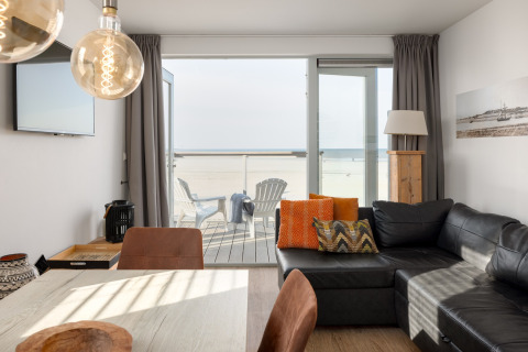 Wohnzimmer eines Strandhauses im Resort Hoek van Holland, Niederlande, mit Meer- und Terrassenblick.