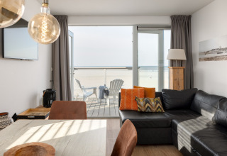 Wohnzimmer eines Strandhauses im Resort Hoek van Holland, Niederlande, mit Meer- und Terrassenblick.