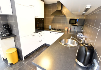 Cucina moderna nella Villa «Avondrood» nei Paesi Bassi, con elettrodomestici e lavello integrato.