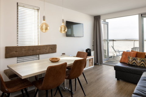 Modernes Wohn- und Esszimmer in einem Strandhaus im Resort Hoek van Holland mit Meerblick und stilvollem Design.