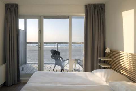 Aussicht vom Schlafzimmer eines Strandhauses im Resort Hoek van Holland, mit Meerblick und Sonnenuntergang.