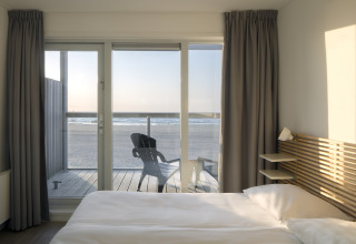 Aussicht vom Schlafzimmer eines Strandhauses im Resort Hoek van Holland, mit Meerblick und Sonnenuntergang.