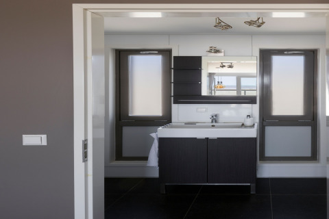 Modernes Badezimmer mit Waschbecken, Spiegel und Fenstern im Resort «Hoek van Holland», Niederlande.