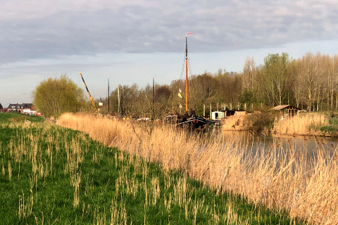 Udsigt over grønne marker, siv og en flod ved Villa Avondrood-lodgen i Holland på en solrig dag.
