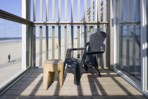 Balkon im Resort Hoek van Holland in den Niederlanden mit Blick auf den Strand, Stuhl und Hocker.