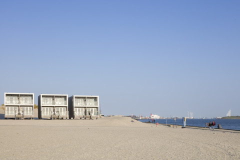 Strandhäuser im Resort Hoek van Holland, Niederlande, mit ruhigem Strand und Meerblick im Hintergrund.