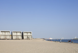 Strandhäuser im Resort Hoek van Holland, Niederlande, mit ruhigem Strand und Meerblick im Hintergrund.