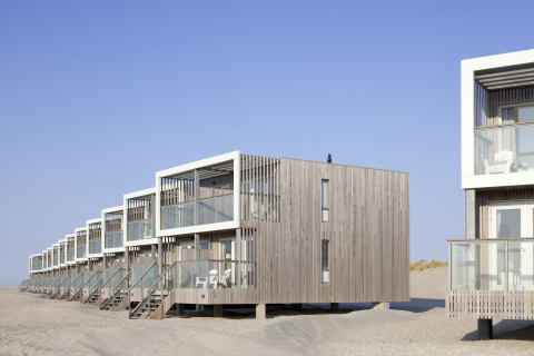 Reihe moderner Strandhäuser im Resort Hoek van Holland, Niederlande, mit Holzfassaden und Balkonen.