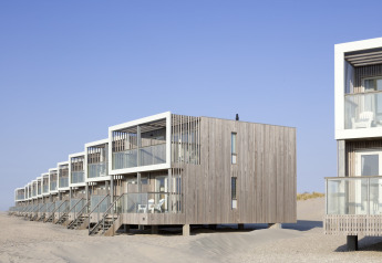 Fila de casas modernas en la playa en el Resort Hoek van Holland, Países Bajos, con balcones de madera.