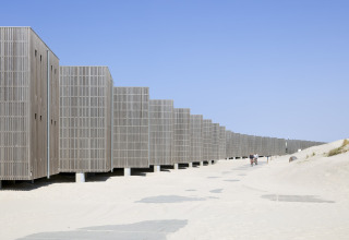 Moderne Strandhäuser im Resort Hoek van Holland in den Niederlanden mit Sand und blauem Himmel.