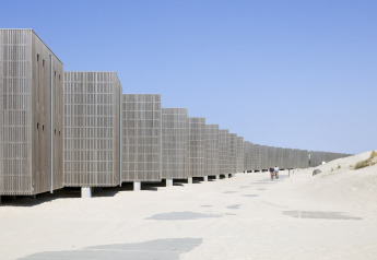 Casas de playa modernas en Resort Hoek van Holland, Países Bajos, rodeadas de arena y cielo despejado.
