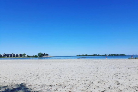 Strandblick beim Resort Hoek van Holland in den Niederlanden mit blauem Himmel und ruhigem Wasser.