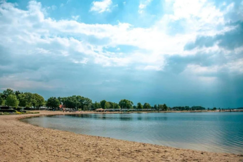 Strandblick am Resort Hoek van Holland in den Niederlanden mit Sand, ruhigem Wasser und blauem Himmel.
