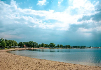 Vista de playa en el Resort Hoek van Holland en los Países Bajos con agua tranquila y cielo azul.