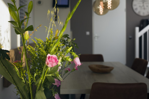 Nahaufnahme eines Blumenstraußes auf einem Esstisch in einem hellen Raum im Resort Hoek van Holland, Niederlande.