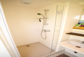 Ducha moderna con rociador de mano en un pequeño y luminoso baño de un apartamento cerca de la costa en los Países Bajos.