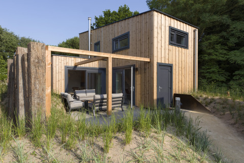 Modern beach house at Noordzee Resort Vlissingen 3 with outdoor seating and natural surroundings.