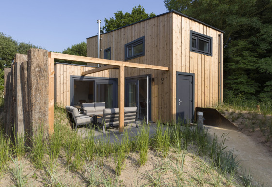 Modern beach house at Noordzee Resort Vlissingen 3 with outdoor seating and natural surroundings.