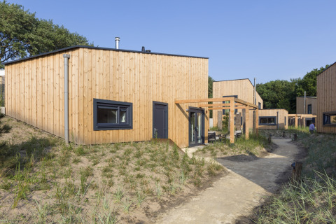 Moderne Holzstrandhäuser im Noordzee Resort Vlissingen 2 mit Sandwegen und natürlicher Umgebung.