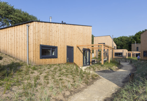Moderne Holzstrandhäuser im Noordzee Resort Vlissingen 2 mit Sandwegen und natürlicher Umgebung.
