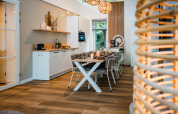 Modern lodge kitchen and dining area with wood flooring, contemporary decor, and inviting lighting.