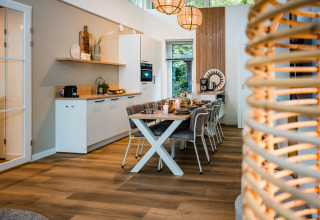 Moderne lodgekøkken og spisestue med træmøbler, stilfuld belysning og hyggelig atmosfære.