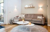 Modern lodge living area with a beige corner sofa, stylish tables, soft lighting, and a cozy ambiance.
