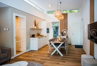 Moderne lodge-stue med hyggelig spiseplads, nordisk indretning og store vinduer med naturligt lys.