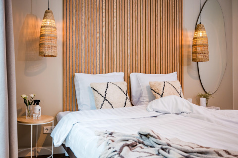 Camera da letto di un lodge moderno con letto matrimoniale, pannello in legno e lampade sospese.