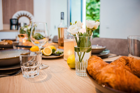 Frühstückstisch in einer Lodge mit Croissants, Zitronen, frischen Blumen und eleganten Gläsern.